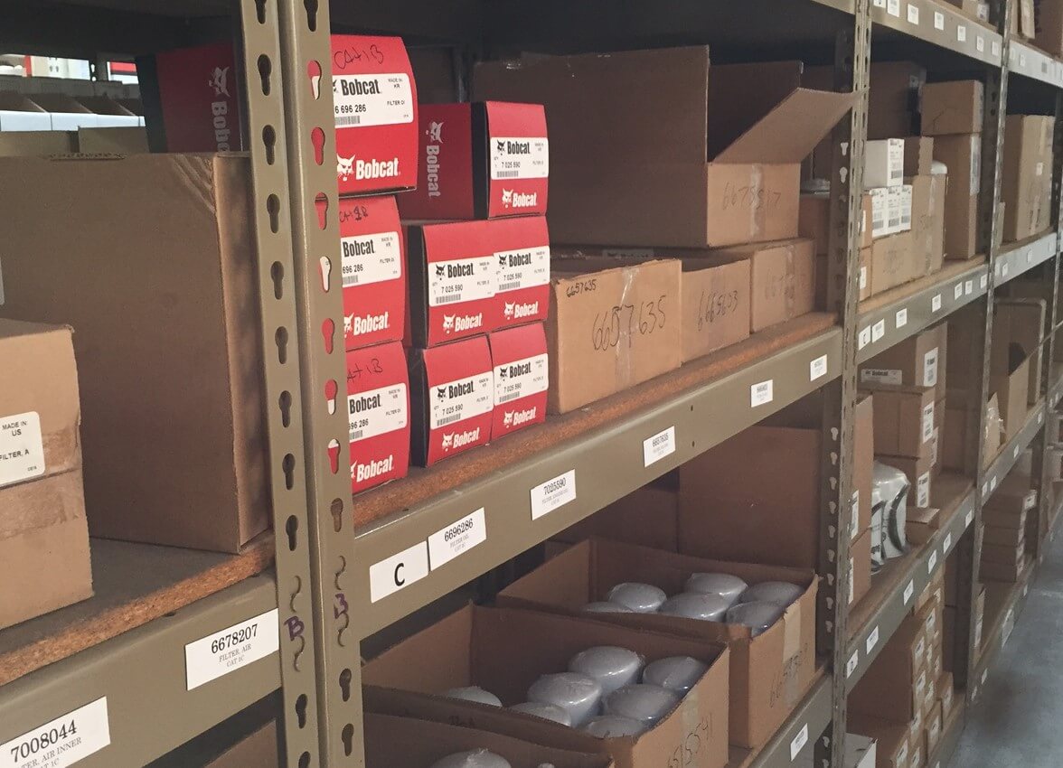 A shelf with different boxes of Bobcat® parts